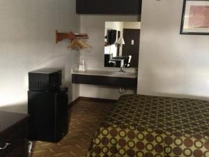a hotel room with a bed and a sink at Americas Best Value Inn Kansas City East - Independence in Independence
