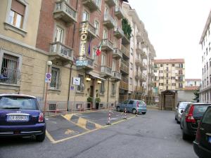 un estacionamiento con autos estacionados frente a un edificio en Hotel Air Palace Lingotto en Turín