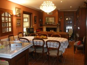a dining room with a table and chairs and a fireplace at Casa Alpargateiro in Os Peares