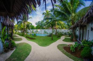 a garden with palm trees and a swimming pool at Palaka Resort in General Luna