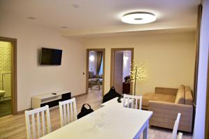 a living room with a table and a couch at Ąžuolo apartamentai in Birštonas