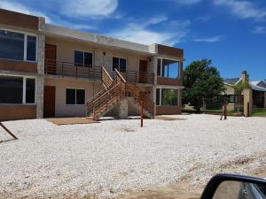 una casa con una escalera delante de ella en Complejo Rafina Villa Gesell en Villa Gesell