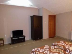 a bedroom with a bed and a dresser and a television at Kafana "Kaj Zoki" in Probi&scaron;tip