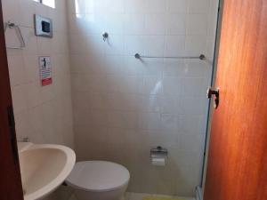 a bathroom with a toilet and a sink at Apartamento em Cabo Frio in Cabo Frio +15 photos