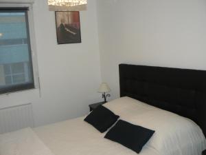 um quarto com uma cama com uma cabeceira preta e uma janela em Cocooning Villa em Cherbourg en Cotentin
