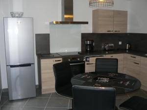 uma cozinha com uma mesa e cadeiras e um frigorífico em Cocooning Villa em Cherbourg en Cotentin