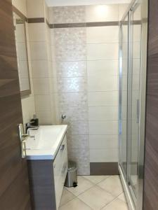 y baño con lavabo y ducha. en Apartments Ogrin, en Portorož
