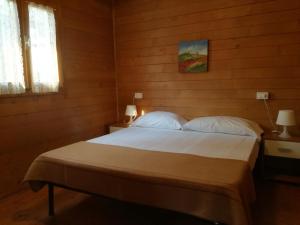 a bedroom with a bed with white sheets and pillows at Campeggio Italia in Marina di Massa