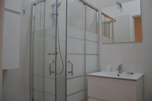 a bathroom with a glass shower and a sink at La Giara in Torre Lapillo +8 photos