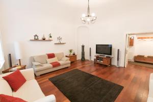 a living room with a couch and a tv at Design Apartment Eger in Eger