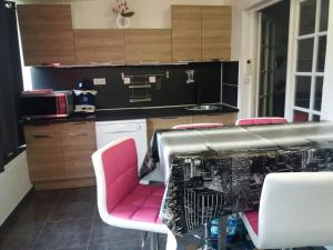 una cocina con mesa y sillas rosas. en cavaliere studio 2 pers, en Le Lavandou 4 fotos más