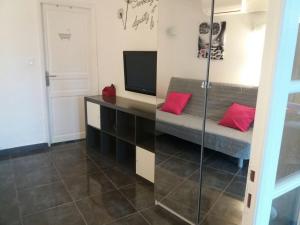 a living room with a couch and a tv at cavaliere studio 2 pers in Le Lavandou