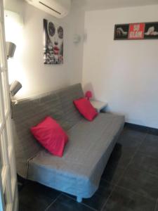 a couch with two red pillows in a room at cavaliere studio 2 pers in Le Lavandou