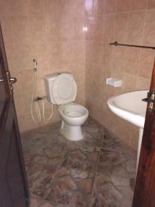 a bathroom with a toilet and a sink at Iris Hotel Dar Es Salaam in Dar es Salaam