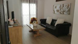 a living room with a black couch and a table at Piso vacacional, Mijas Pueblo in Mijas