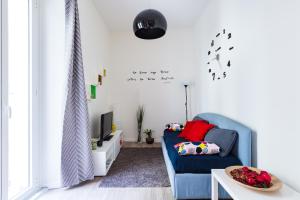 een woonkamer met een blauwe bank en een tv bij Sixty One Luxury Room in Rome