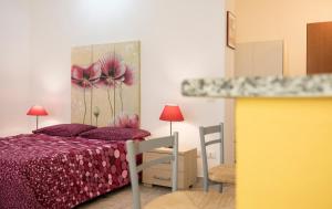 1 dormitorio con 1 cama y una pintura de flores en Il Giardinetto, en Alghero