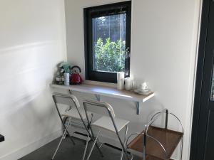 een tafel en 2 stoelen in een kamer met een raam bij Bij Zelle in Garderen