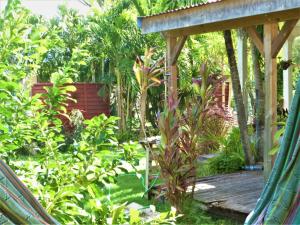 um jardim com uma ponte de madeira e algumas plantas em Karukera em Saint-François