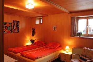 a bedroom with two beds with red sheets and a window at Chasa Crush 117 in Ardez +54 photos