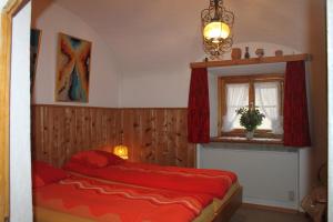 een slaapkamer met een rood bed en een raam bij Chasa Crush 117 in Ardez