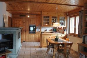 a kitchen with wooden cabinets and a table in a room at Chasa Crush 117 in Ardez