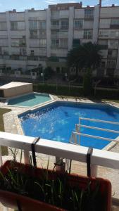 una grande piscina blu di fronte a un edificio di La Pineda Beach a La Pineda