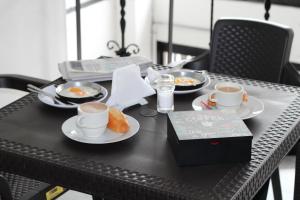 una mesa con dos tazas de café y platos de comida en Hotel Elegant Suite, en Bogotá