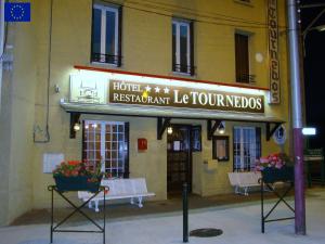 a hotel with two benches in front of a building at Le Tournedos in Lézignan-Corbières