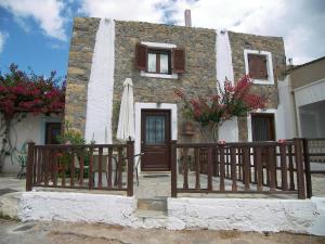 una pequeña casa con una puerta y una sombrilla en Hiona Cottage, en Palaikastro