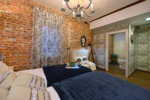 Dormitorio con paredes de ladrillo, cama y sofá en Center Suite Santander, en Santander