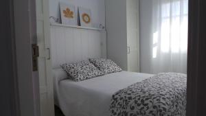 a small bedroom with a bed with two pillows on it at Casa mirador in Adeje