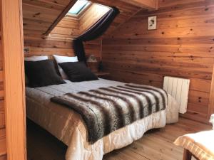 una camera con un letto in una baita di tronchi di Chalet La Grande Ourse a Saint-Gervais-les-Bains