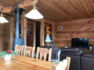 una sala da pranzo con tavolo, sedie e televisione di Chalet La Grande Ourse a Saint-Gervais-les-Bains