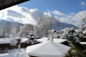 a house covered in snow with trees and mountains at Privát Prima in Liptovský Ján