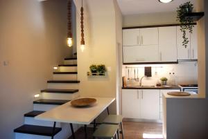 a small kitchen with a table and a staircase at To Spiti - Pelion House in Kala Nera