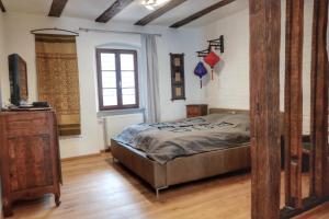 ein Schlafzimmer mit einem Bett, einer Kommode und einem Fenster in der Unterkunft Altstadt Blieskastel, Gerbergasse in Blieskastel