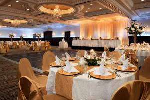 un salón de banquetes con mesas y sillas blancas en Radisson Hotel Cincinnati Riverfront en Covington