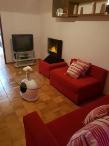 a living room with two red couches and a television at Apartamento Fuseta in Fuzeta