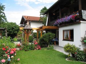 a garden in front of a house with flowers at Gästehaus Frankl in Rottau
