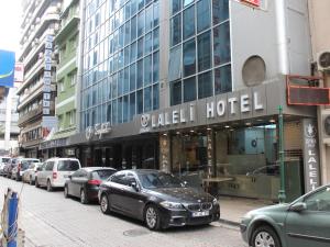 a street with cars parked in front of a hotel at Laleli Hotel Izmir in Izmir