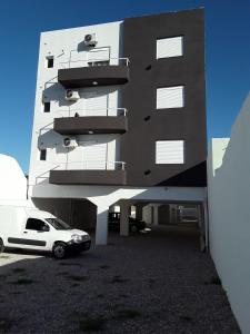 a white car parked in front of a building at Departamentos Solares - Bravard in Bahía Blanca