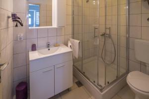 a bathroom with a shower and a sink and a toilet at Apartments Danica in Vrbnik +13 photos