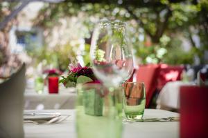 a table with a wine glass and flowers on it at Altmann's Stube in Erlangen