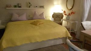 um quarto com uma cama amarela e uma colcha amarela em Ferienwohnung Heinrich em Altenau