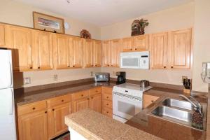 a kitchen with wooden cabinets and white appliances at GreatRentalKeystone in Keystone