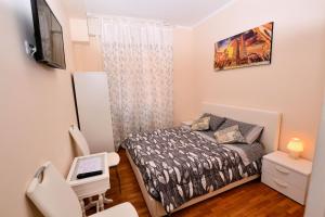 Habitación pequeña con cama y escritorio. en B&B Lidiya, en Bolonia