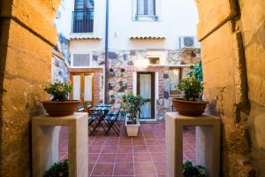 a courtyard with two potted plants on two pillars at Il Cortiletto di Ortigia in Siracusa