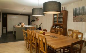 kuchnia i jadalnia z drewnianym stołem i krzesłami w obiekcie Beautiful and Spacious Contemporary house w mieście Oignies