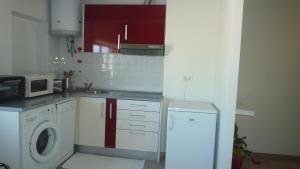 a kitchen with a washing machine and a microwave at Casa Mar in Costa da Caparica